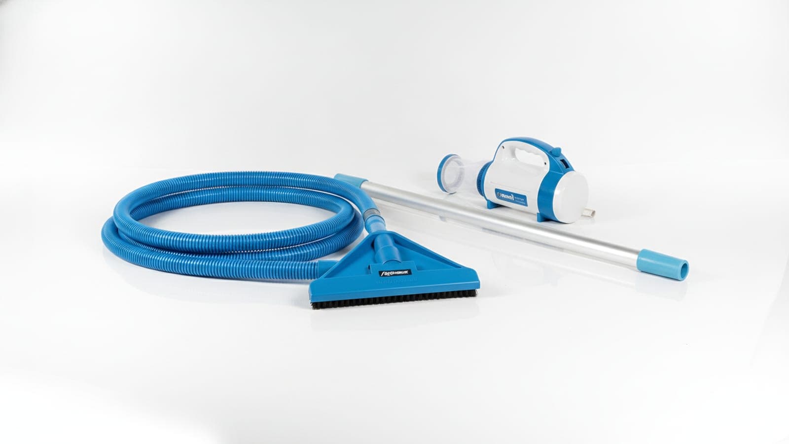 Manual pool vacuum head, hose, and skimmer net arranged beside an above-ground pool